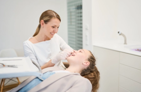 Bei jedem Termin kontrolliert eine Zahnärztin den Behandlungsfortschritt während Kieferorthopädie in Wolfratshausen.