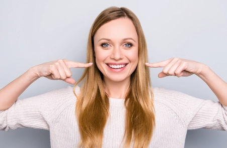lachende, glückliche Frau, die nach CMD Behandlung mit Funktionsdiagnostik und CMD-Schiene keine Zahnschmerzen, Kieferschmerzen und Kopfschmerzen mehr hat